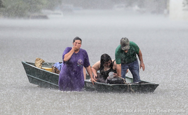 The heavy rainfall gives a family trouble when transporting their belongings. (Photo by David Grunfeld, NOLA.com | The Times-Picayune)